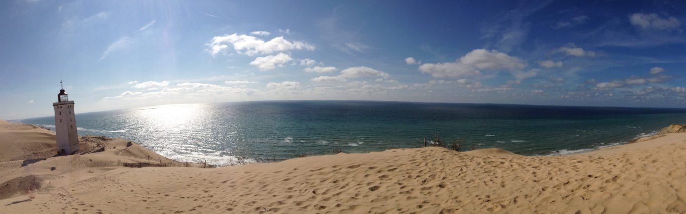 Lösungen sehen Leuchtturm auf Sanddüne mit klarem Blick auf den Horizont für Lösungen